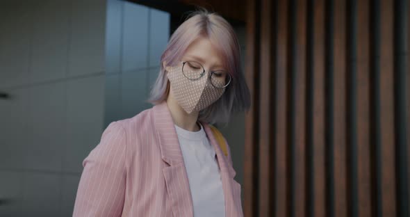 Cheerful Young Woman Wearing Face Mask Using Smartphone Walking Outdoors alt