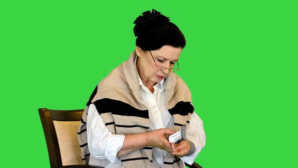 Senior Woman Having Arterial Pressure on a Green Screen Chroma Key alt