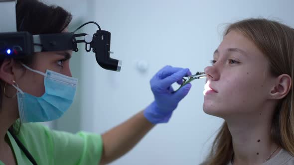 Closeup Side View Positive Otolaryngologist Using Ent Headlight Examining Nasal Canal of Patient in alt