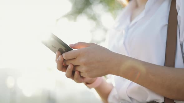 Close-up hands Asian businesswoman in a white shirt is using a smartphone.