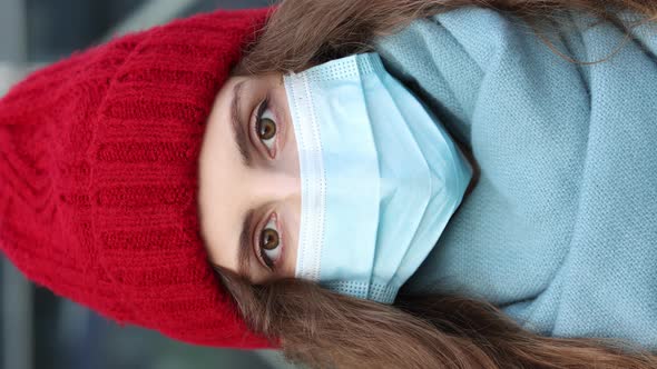 Vertical Shot of Close up Portrait of Curly Female in Medical Mask Standing in Winter City