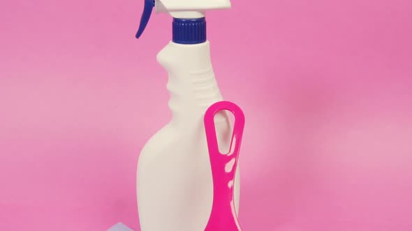 A Plastic Spray Bottle with Household Chemicals and a Window Cleaning Scraper