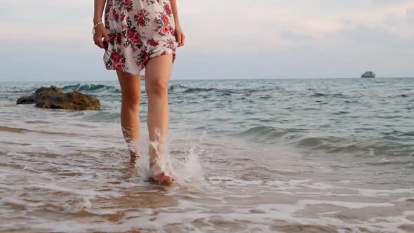 Young woman in dress walking on beach