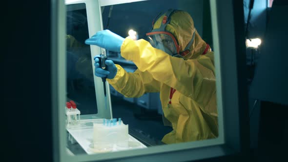 Laboratory Worker Holds a Pipette and Tube While Developing a Coronavirus Vaccine. alt