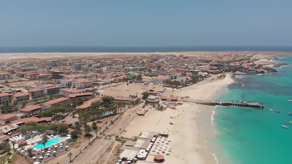 Aerial footage of the famous pier at Cape Verde, fishermen with fishermen's wives selling the fish