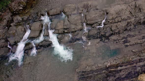 Aerial view of mountain river with cold clear water. The river flows over the stones alt