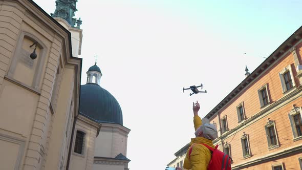 A Man Catches a Drone with His Hands While Landing in the City