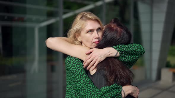 Hypocritical Woman Hugging Friend with Dissatisfied Annoyed Facial Expression alt