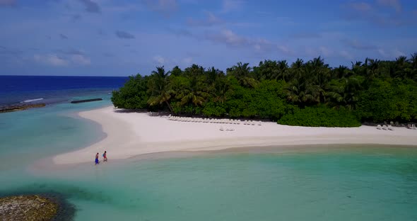 Wide angle overhead clean view of a white paradise beach and blue sea background in colourful 4K alt