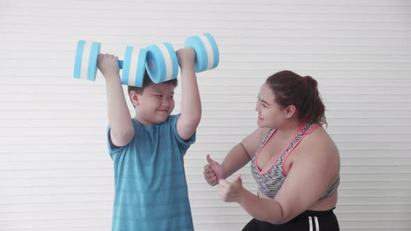 Asian family mother training with son fat exercise with dumbbell and at home, boy obesity workout. alt