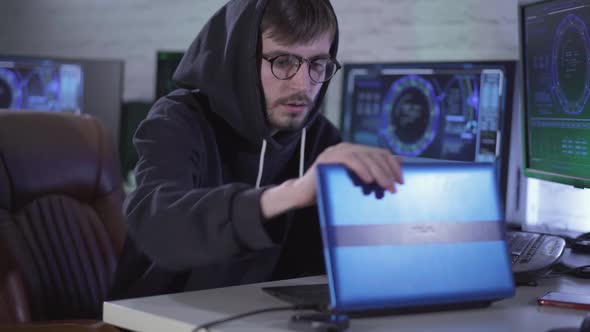 Confident Thoughtful Young Hacker Closing Laptop and Sighing. Portrait of Worried Caucasian Man in alt