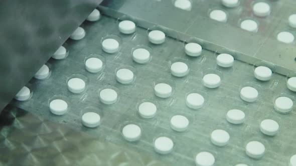 Pills in Blisters Move on a Conveyor Belt