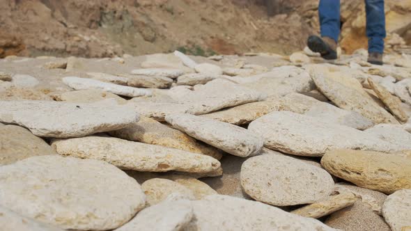 Man Walking Over Rocks and Sand alt