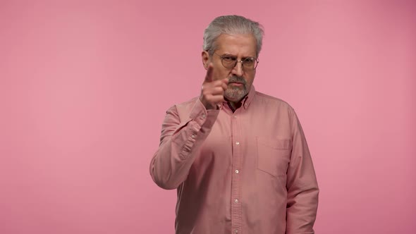 Portrait of an Elderly Man with Glasses Threatening Shaking Her Index Finger alt