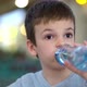 Boy Drinking From Plastic Bottle of Water in Fast Food Restaurant - VideoHive Item for Sale