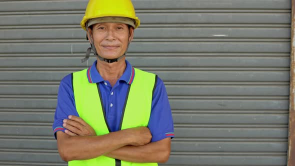 Asian senior male worker smiling and looking at camera