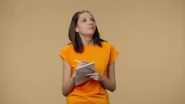 Portrait of Fashion Model Thinking with Concentration and Writing Thoughts and Ideas in Notebook alt