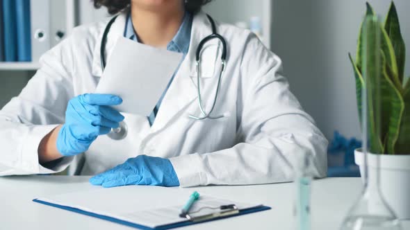 Woman Doctor In A Medical Office Holds A Paper In Her Hand, A Prescription. Medical Doctor's Hand alt
