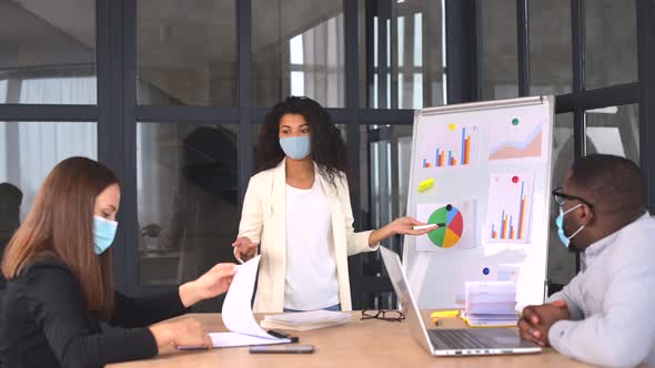 Diverse Work Team in Protective Medical Masks Working in Office During Pandemic alt