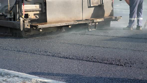 Paver Finisher Placing Layer of Asphalt During Repaving Construction