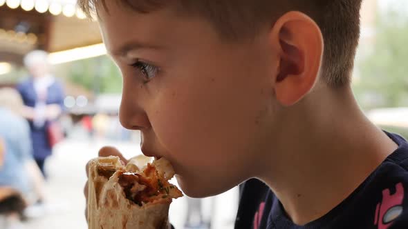 Caucasoid Teenager Boy Eats Juicy Shawarma and Marvels at Its Taste