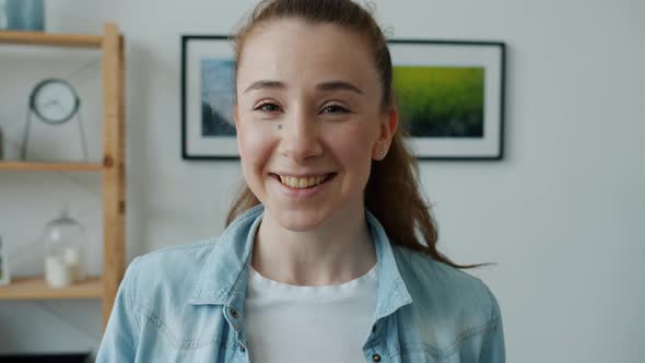 Happy Young Lady Smiling and Laughing Looking at Camera Standing in Modern Light Room alt