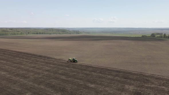 Tractor plows and cultivates the land for sowing alt