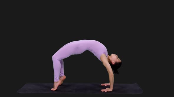 Young Athletic Woman Doing Yoga Bridge Pose on Mat, Alpha in