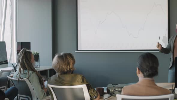 Businessman Delivering Financial Presentation to Team of Colleagues alt