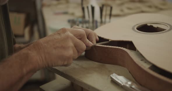 Luthier filing a guitar mold