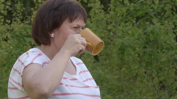 Beautiful Shot of a Middleaged Lady Drinking From a Cup