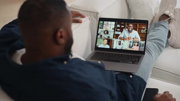AfricanAmerican Guy Making Video Call Greeting Staying at Home Back View alt