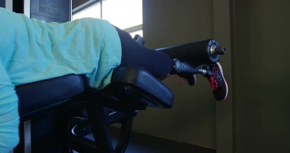 Senior woman exercising on curl machine 4k alt