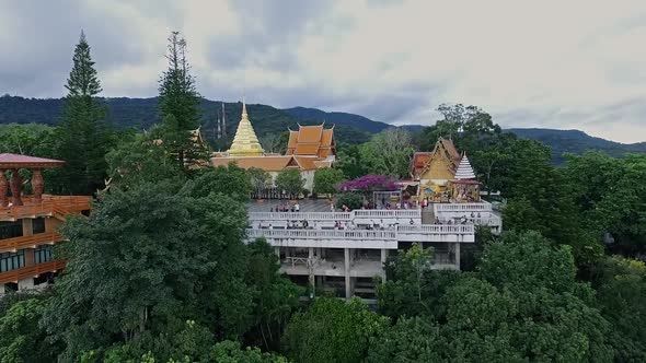 Aerial of Golden Buddhist Temple on Top of Mountain in Chiang Mai, Doi Suthep, Northern Thailand 04