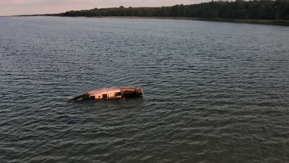 Ocean Horizon View and Boat Wreck Near the Shore Forest Trees in Background alt
