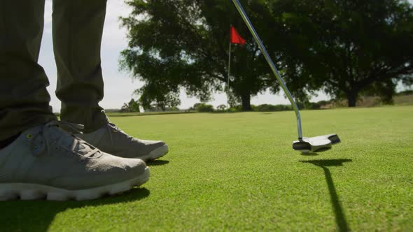 Golf player hitting the ball with his club alt