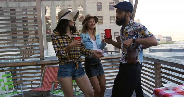 Young adult friends hanging out on a rooftop alt