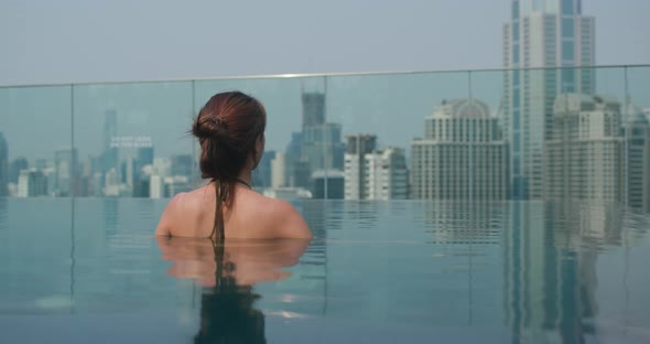 Woman Sit at The Infinity Swimming Pool