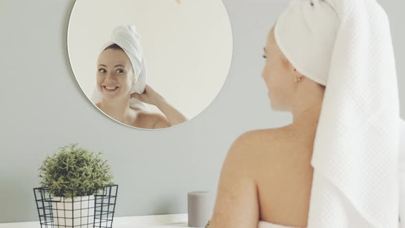 beautiful female admires herself in the bathroom mirror