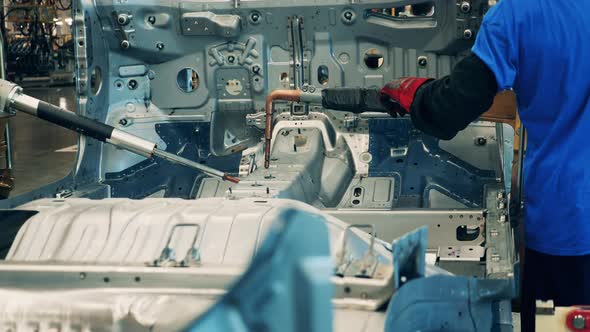 Technicians Are Welding a Large Metal Automotive Carcass alt