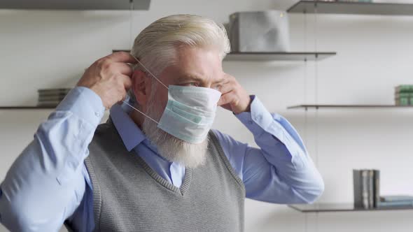 Close Up Portrait of Elderly Man in Medical Face Mask. alt