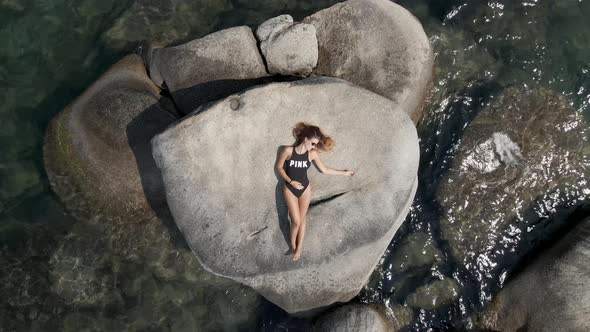 Young Lady Relaxing on the Lake Rocks alt