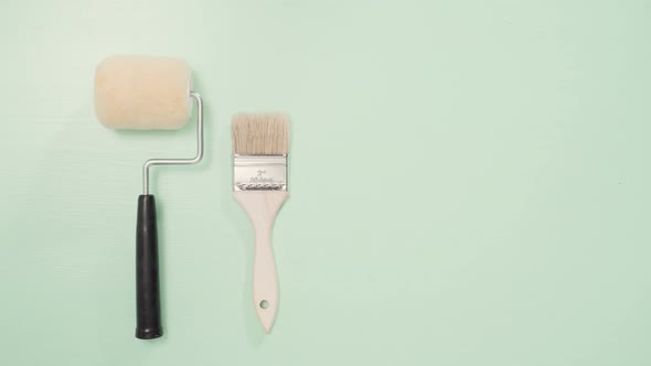 Paint brush and roller for house painting project. alt