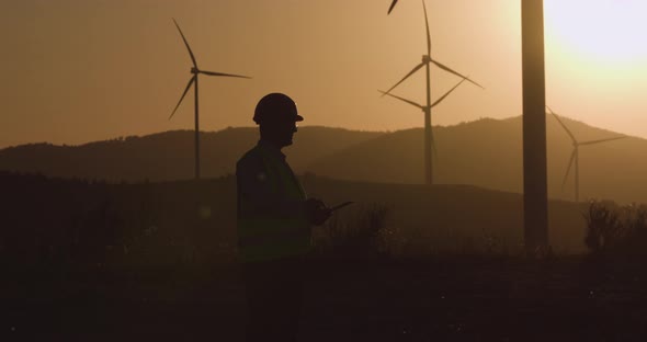 Engineer Looks at the Information in the Tablet, Turning His Head in the Direction of the Windmill alt