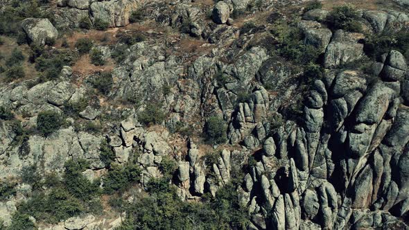 Aerial View of a Cliff Side Enveloped in Rocks Resembling a Stone Wall alt