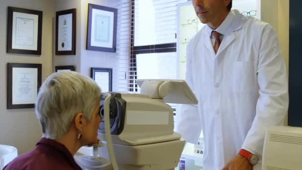 Optometrist examining patient eyes with autorefractors 4k alt