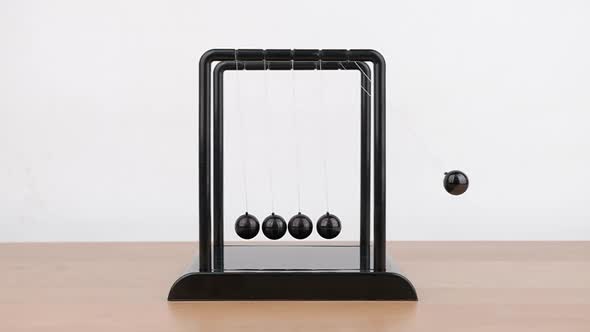 Slow motion, Newton's Cradle metal balls on wooden desk