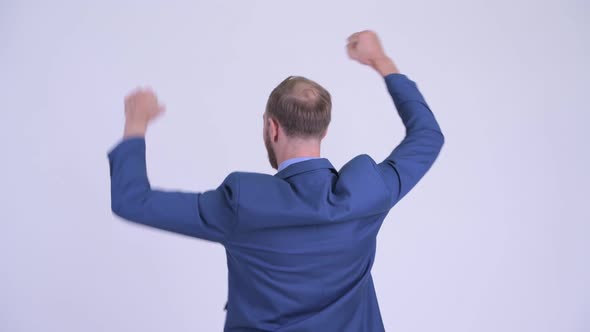 Rear View of Happy Bearded Businessman with Fists Raised