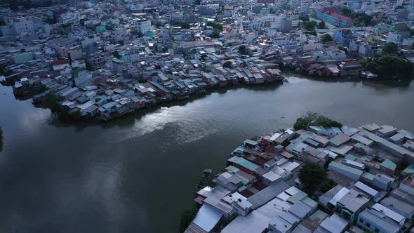 Aerial panning shot of urban canal, reflection and high density waterfront housing and factories in alt