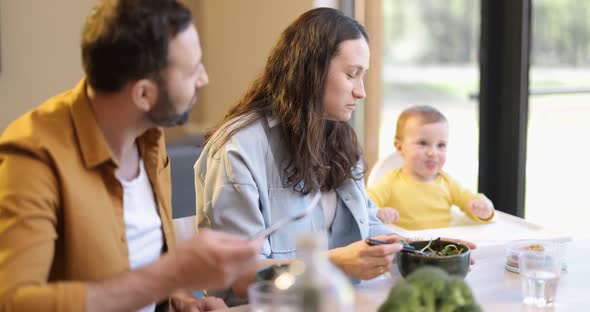 Young Family with a One Year Baby Boy During a Lunch Time at Home alt